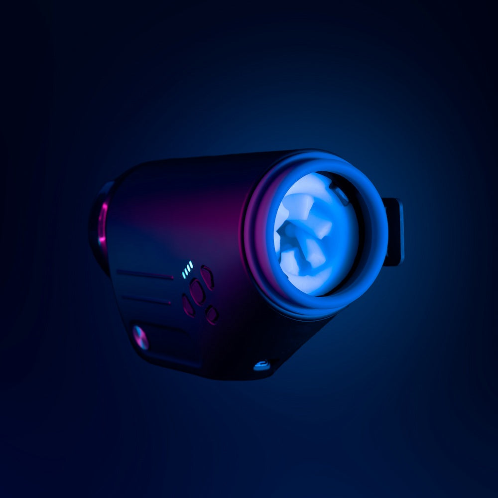 Angled front view of Kaotik Labs The Shotty Interactive Spinning, Thrusting & Vibrating Masturbator under blue and pink lighting, showing the illuminated sleeve opening and control buttons.