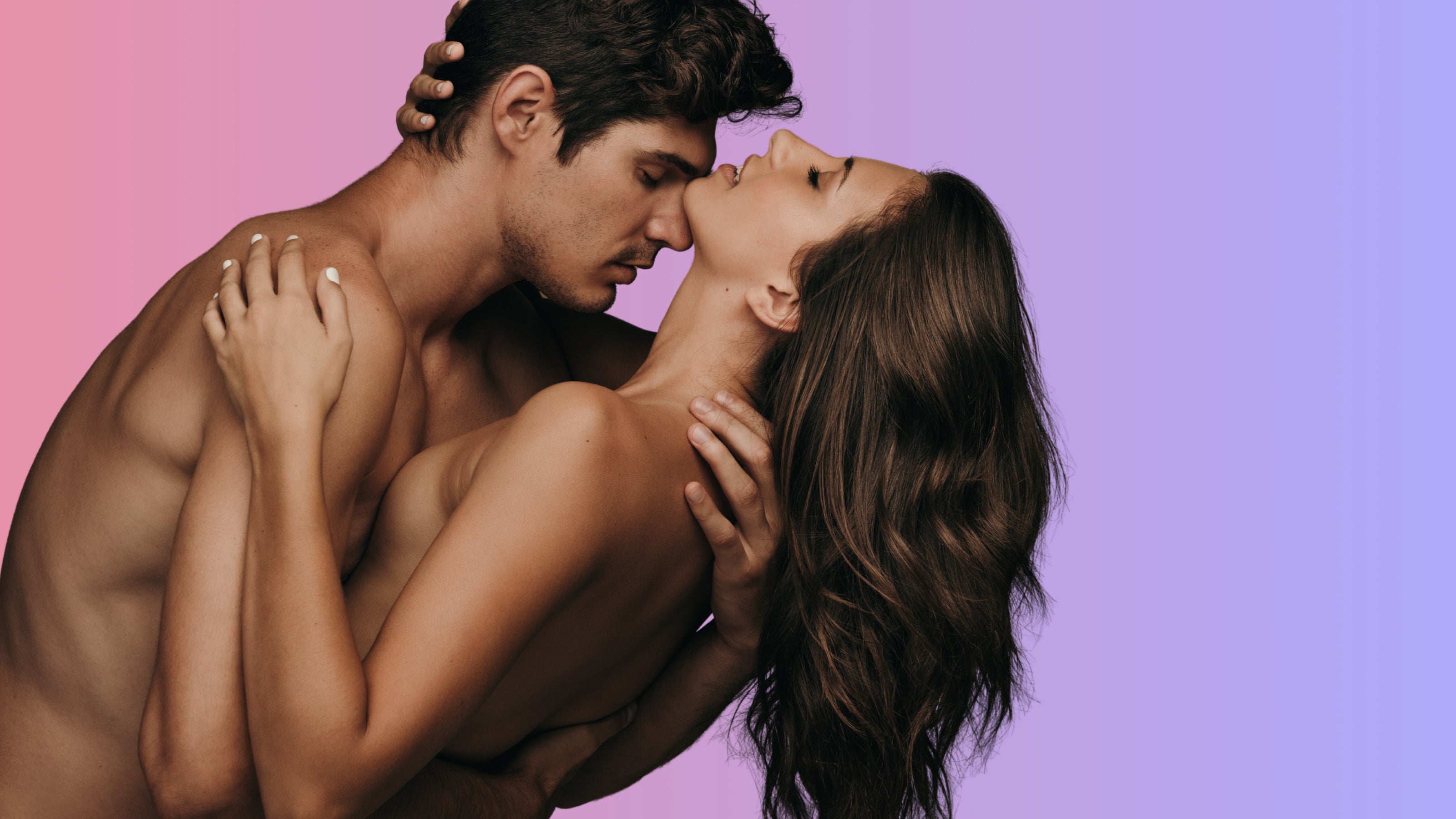 A shirtless man and woman embracing and kissing against a pink-to-purple gradient studio background | OneNightOnly