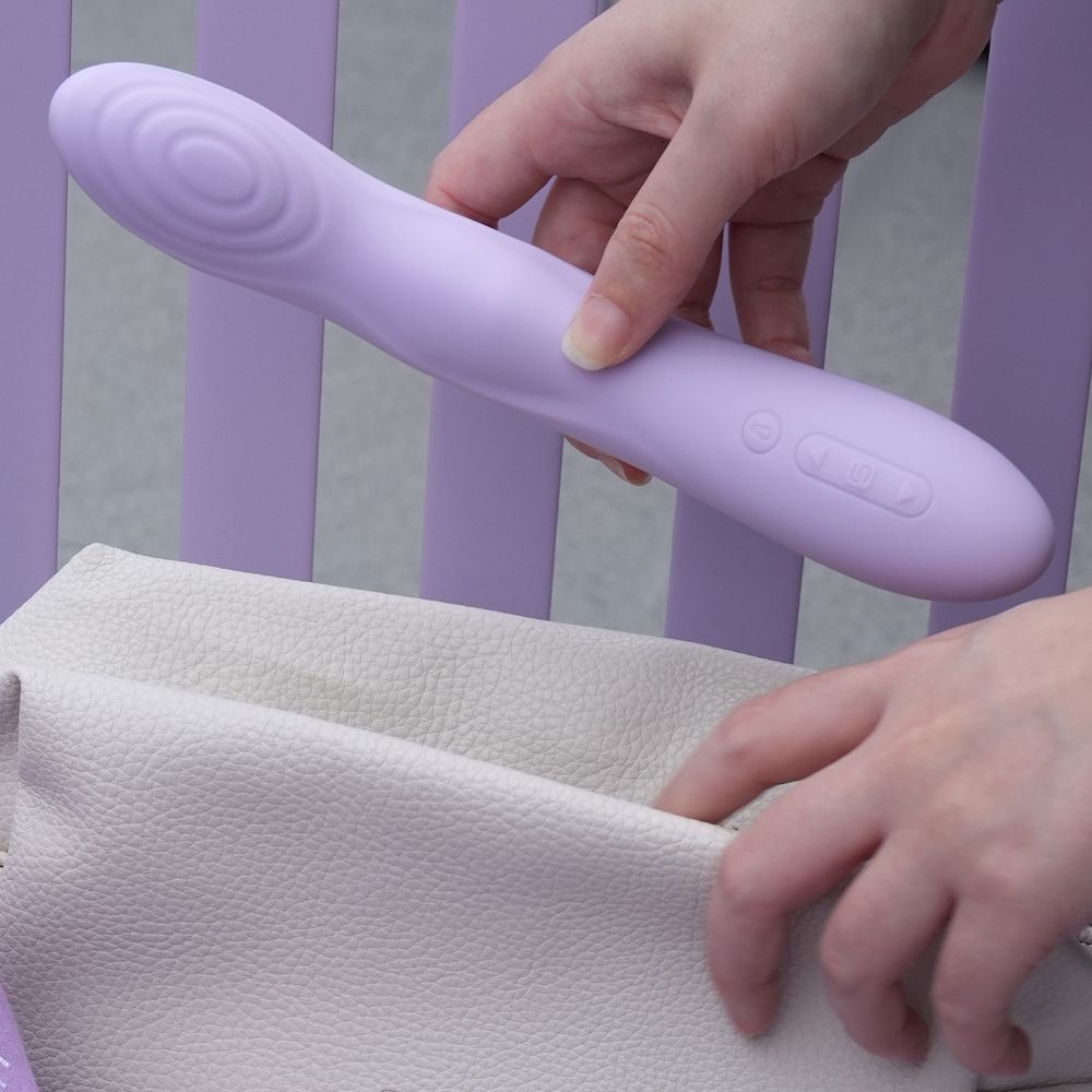 Person holding the Svakom Selena App-Controlled Heating & Thrusting G-Spot Vibrator in front of a striped background