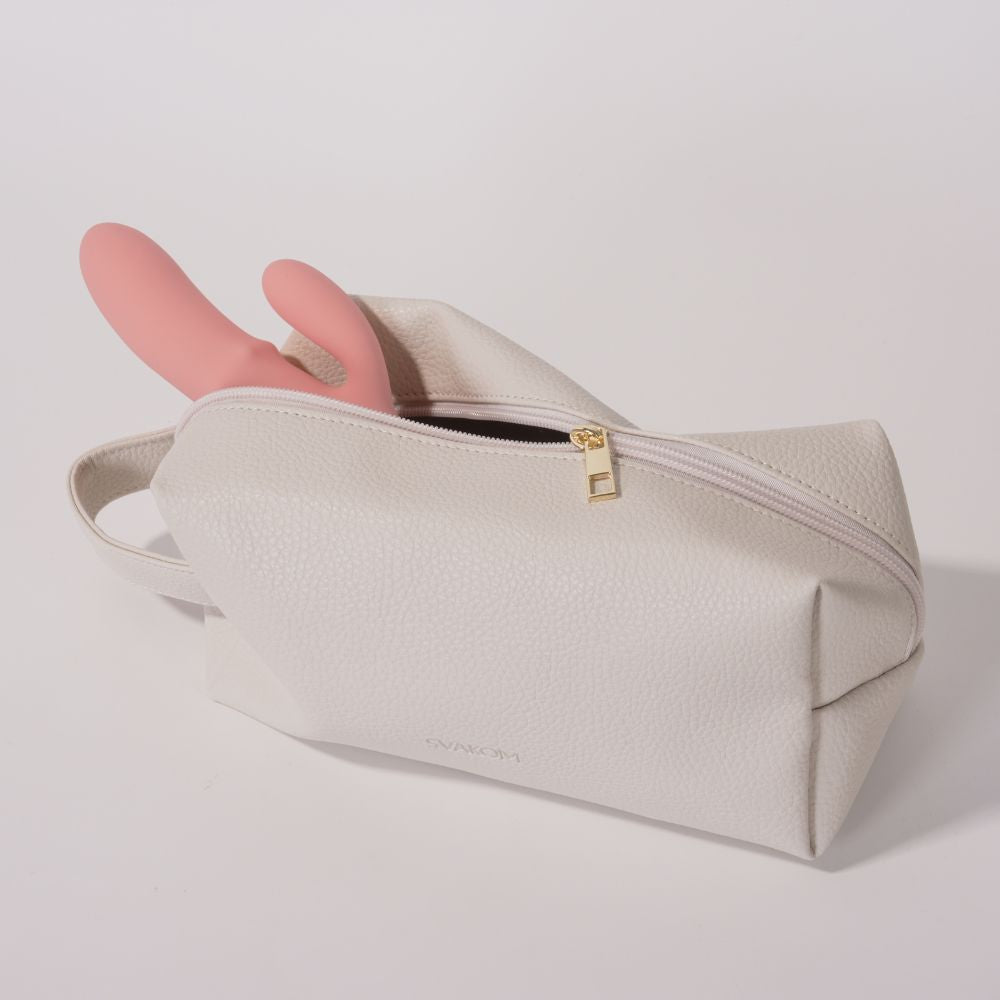 Svakom | Vegan Leather Storage Bag with Carry Handle (Beige) partially unzipped with pink rabbit vibrator visible inside, featuring a gold-tone zipper pull on a soft neutral background