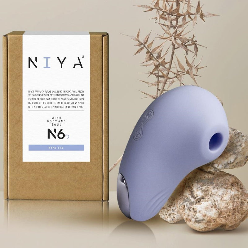 N6 Intimate Air Pressure Stimulator | Niya leaning on a rock with product packaging