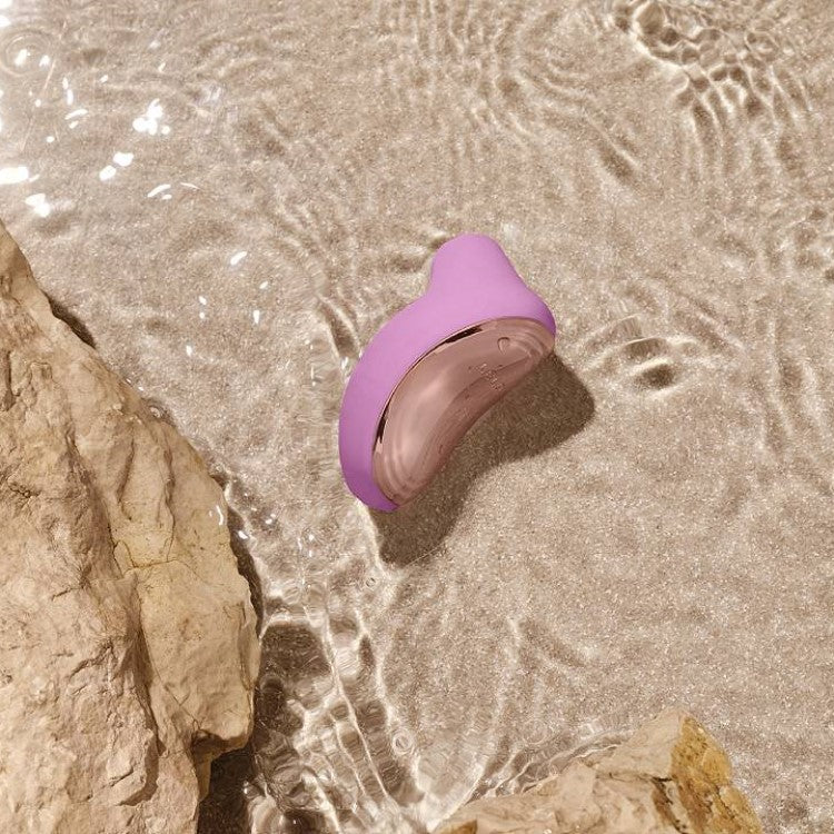 Lelo | Sona 2 Travel Sonic Clitoral Massager (Pink) lying in beach water