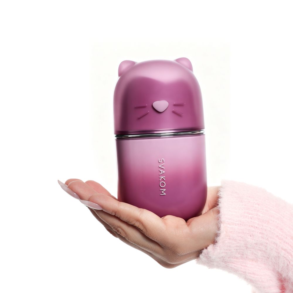 Svakom Klitty Interactive Licking, Sucking & Vibrating Clitoral Stimulator standing upright on an open hand, showing the compact size and cat-shaped design.
