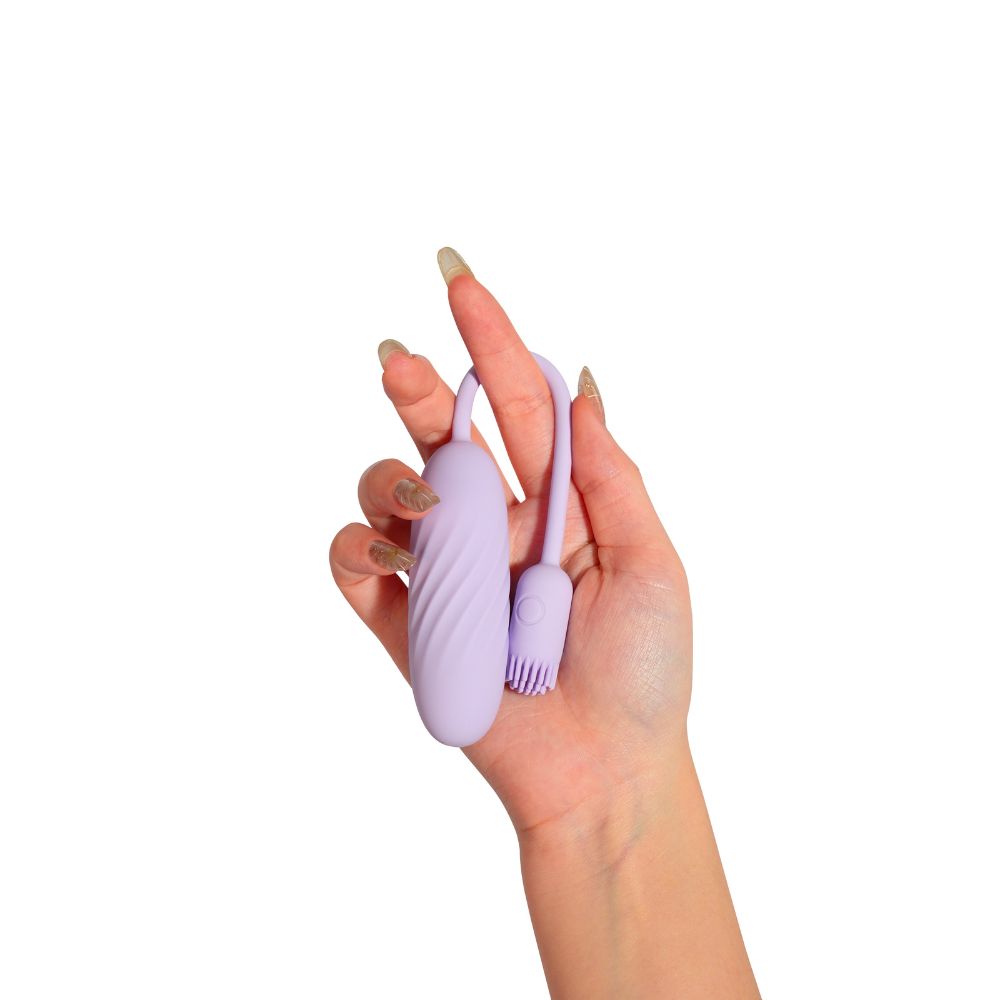 Svakom Plume Interactive Brush Tail Bullet Vibrator in pastel lilac held in one hand, showing the slim bullet body, flexible tail and brush-tip end on a white background.