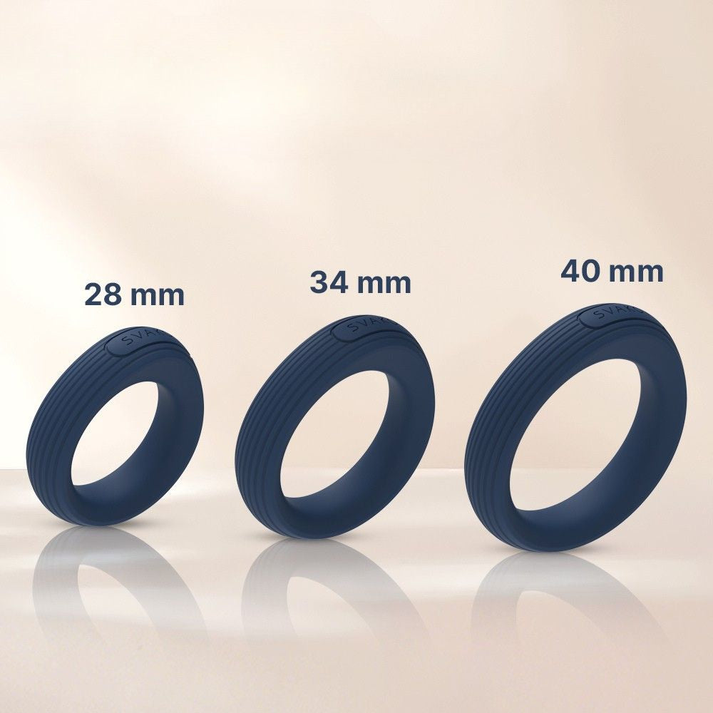 Svakom Triooo Three-Piece Silicone Cock Ring Set showing three dark blue silicone rings labelled 28 mm, 34 mm and 40 mm on a beige surface.