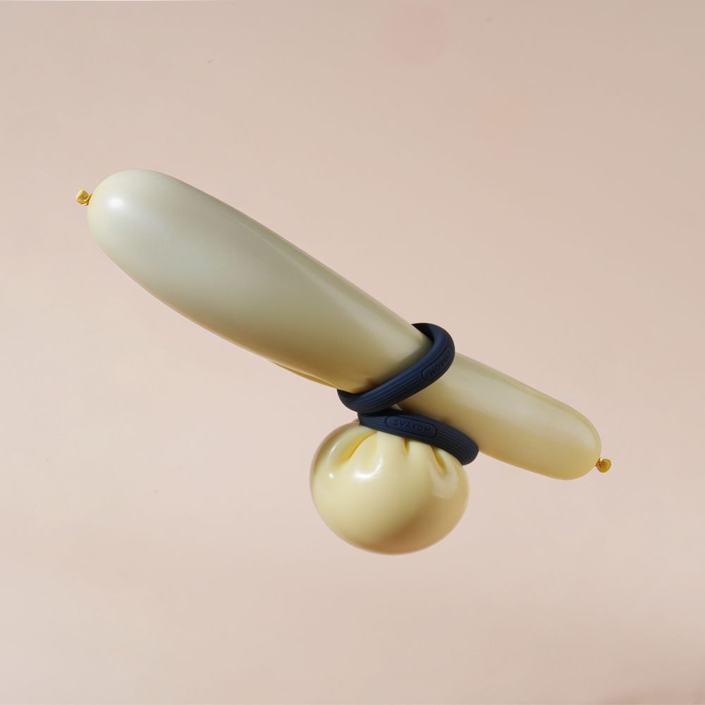 Svakom Triooo Three-Piece Silicone Cock Ring Set shown stretched around inflated balloons to demonstrate flexible fit and use.