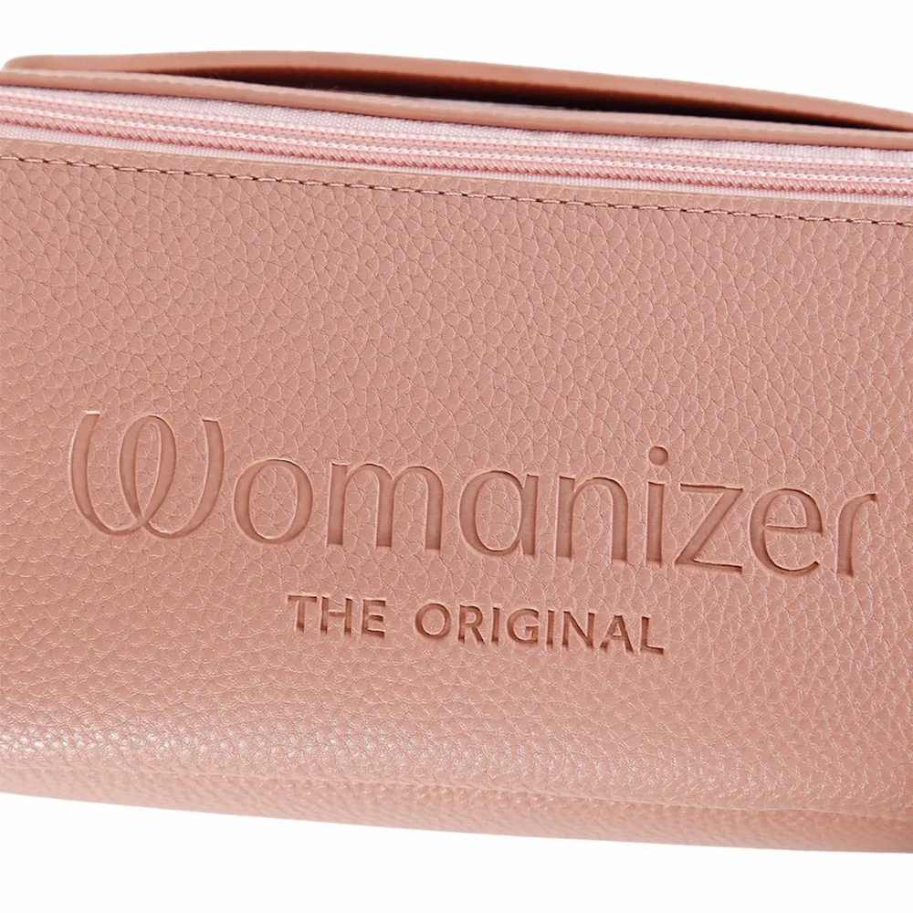 A close-up of the blush pink vegan leather Womanizer Cosmetic Toy Bag with Zip & Carry Handle with the 'Womanizer' logo and the tagline 'THE ORIGINAL' debossed on the front, set against a plain white background