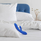 plusOne | Luxe Dual Massager (Blue) lying on a bed