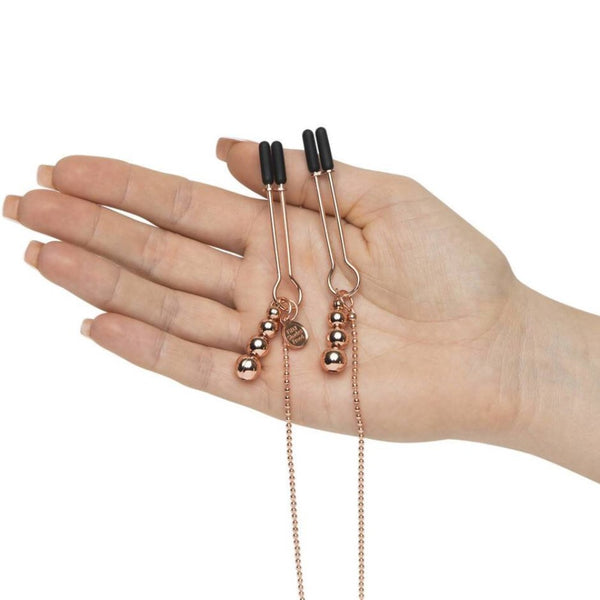 Nipple clamps of All Sensation Nipple & Clit Chain | Fifty Shades in hand 