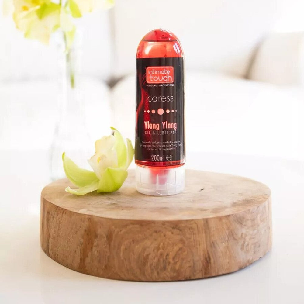 Caress 2-In-1 Massage Gel & Lubricant with Ylang-Ylang (200ml) | Intimate Touch on a wooden stand