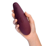 Back view of Classic 2 Clitoral Stimulator | Womanizer - Bordeaux in hand 
