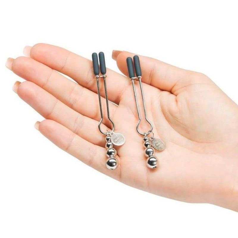 The Pinch Adjustable Nipple Clamps by Fifty Shades in woman's hands